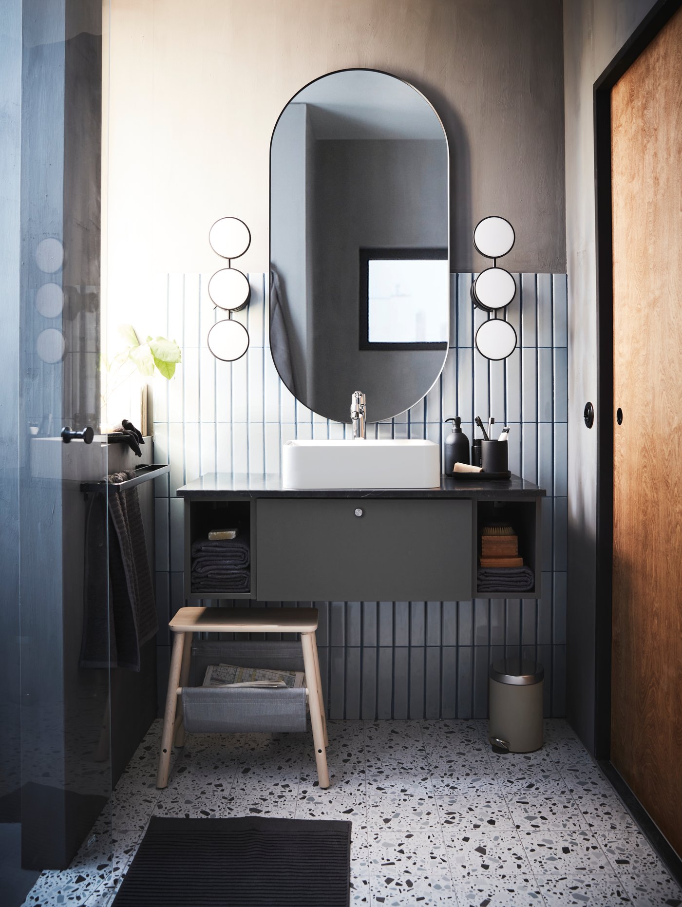 Salle de bain moderne avec miroir ovale et meuble de salle de bain gris anthracite