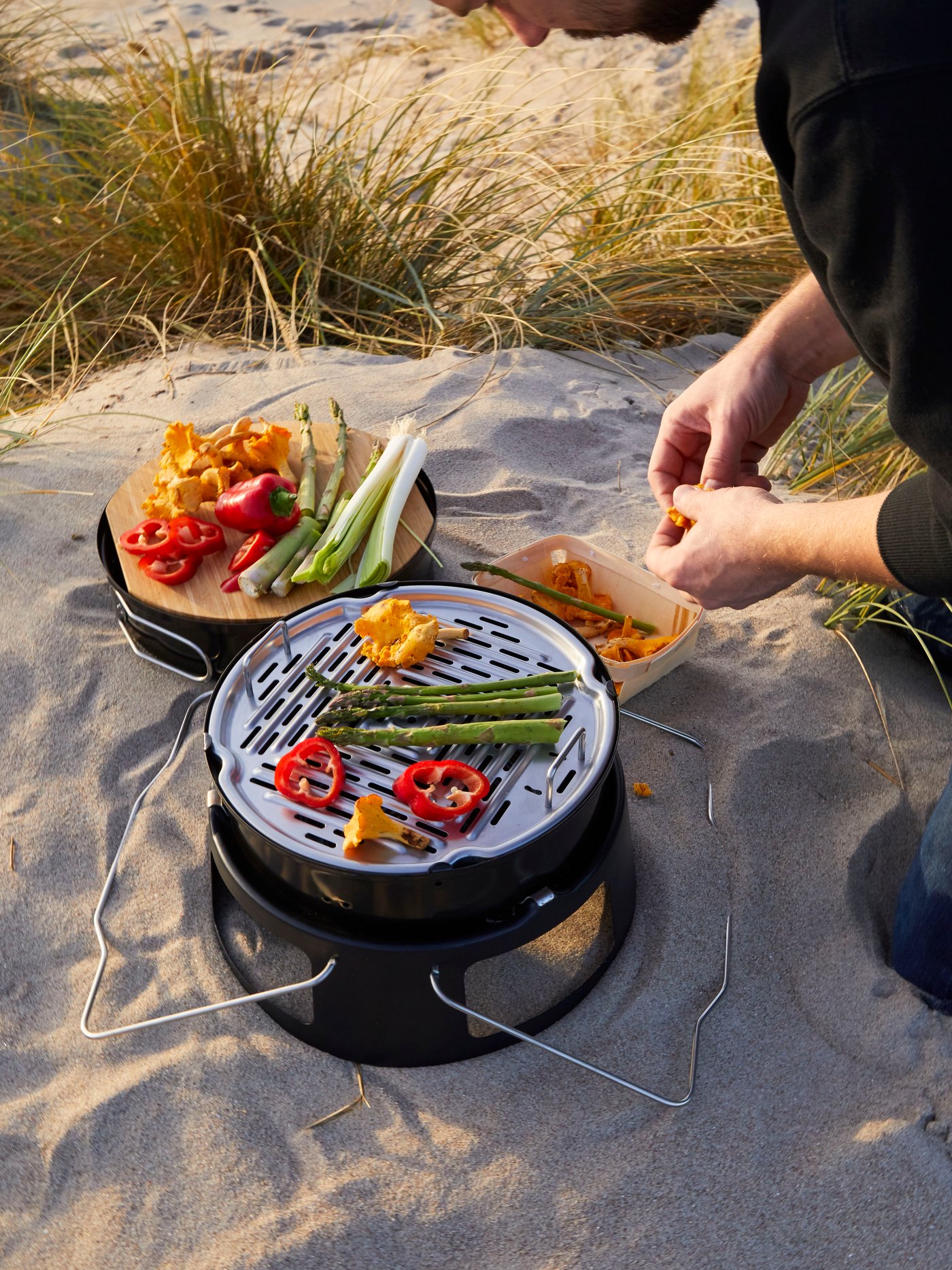 A man holding KÅSEBERGA handplane in wood with a hole for the hand, looking joyous while holding it with both hands.
