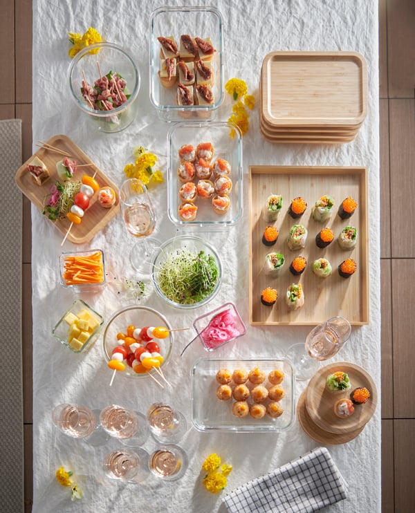 Et bord er dækket op med en buffet af små hapsere der står på fade 