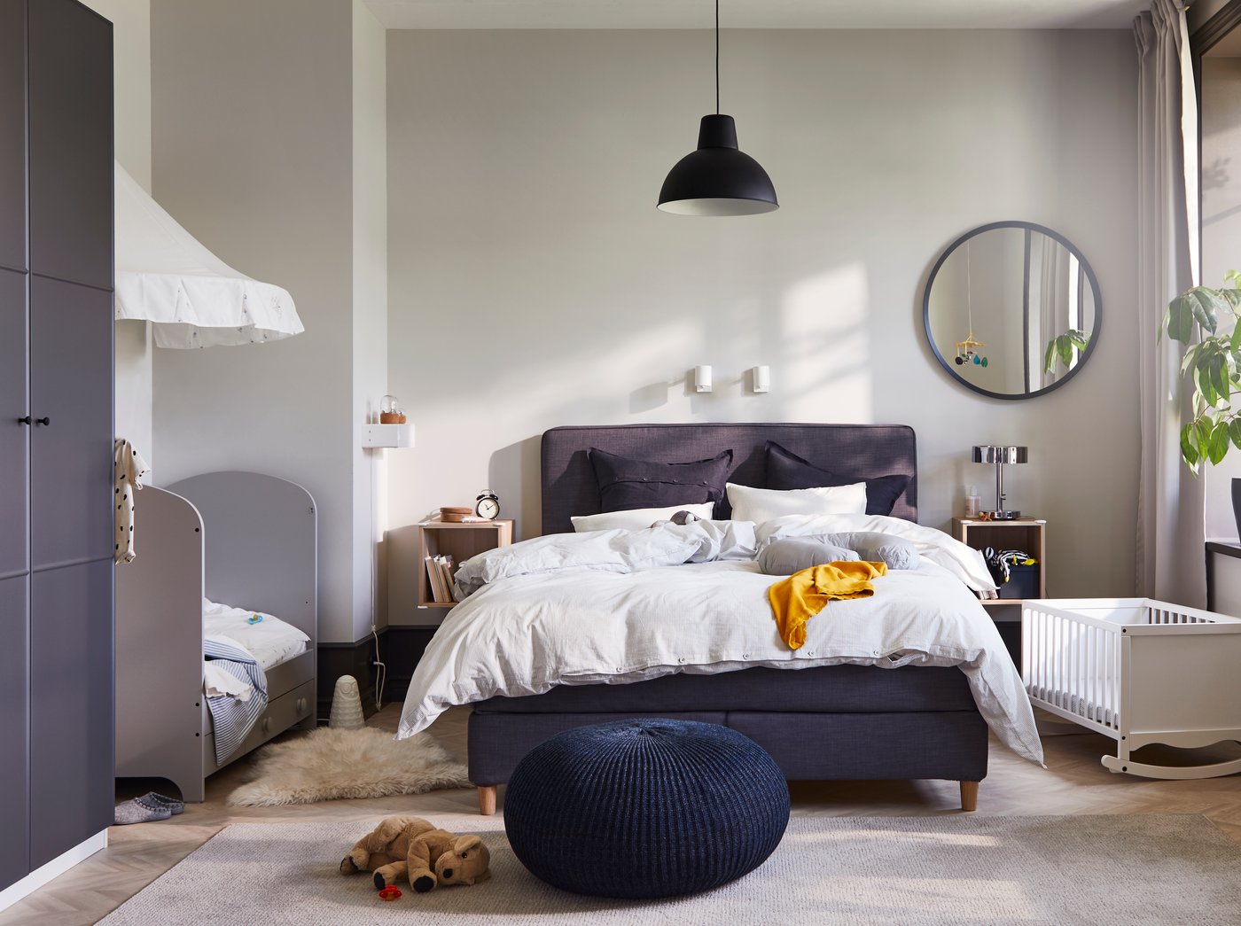 Camera da letto condivisa dai genitori e due bambini, con un sommier DUNVIK in mezzo a un lettino GONATT e una culla SOLGUL bianca.