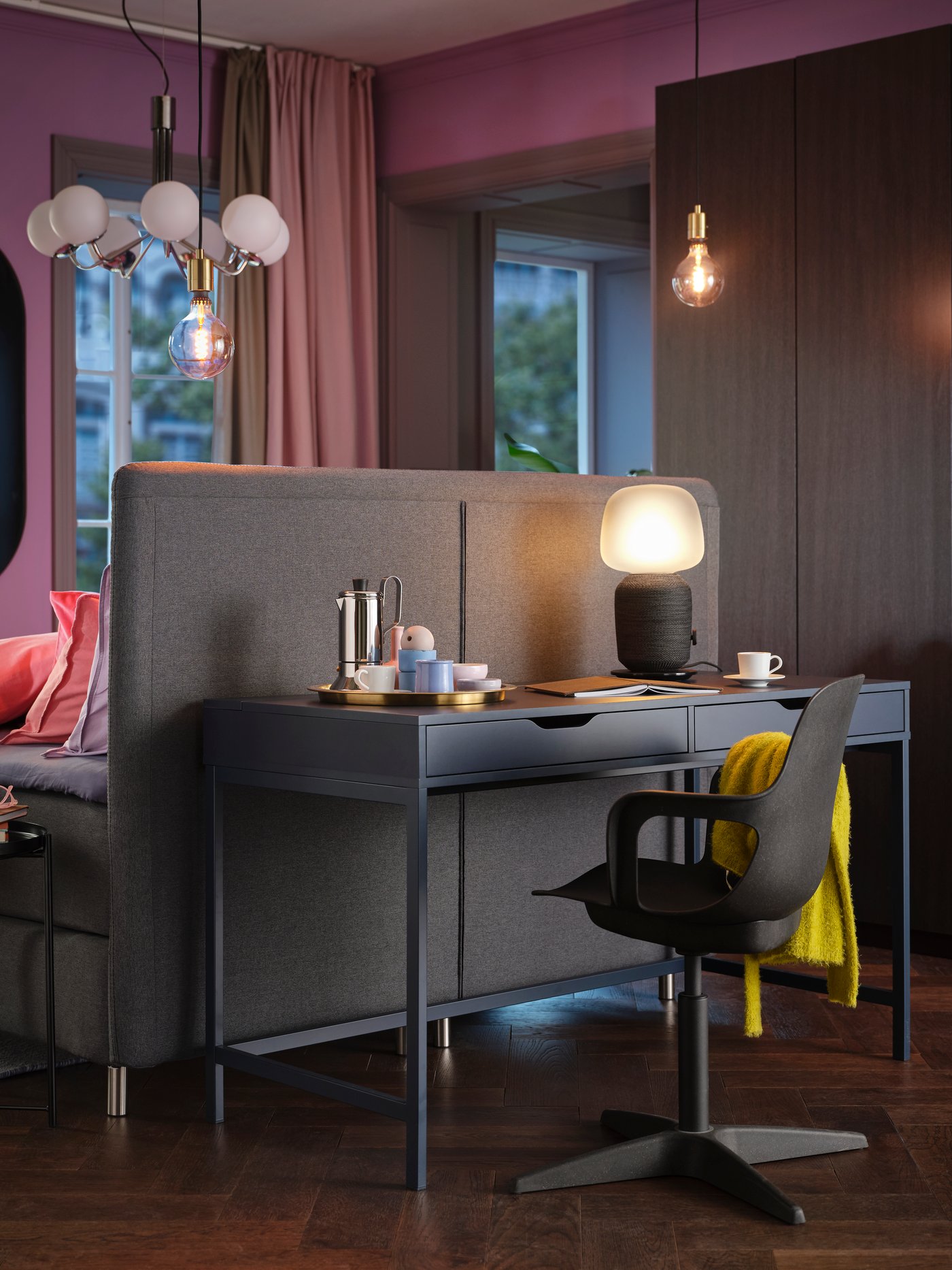 חלק מחדר שינה עם שולחן כתיבה ALEX, מנורה וכיסא ODGER מסתובב מאחורי ראש מיטה של מיטת FINNSNES.