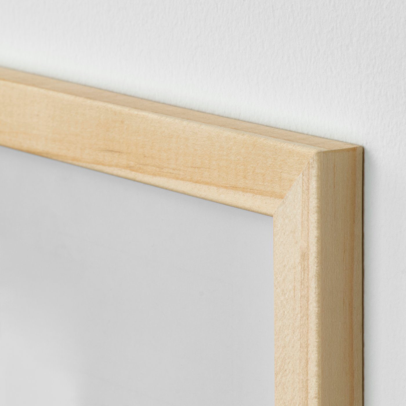 Närbild på hörnet av en ram i furu. 