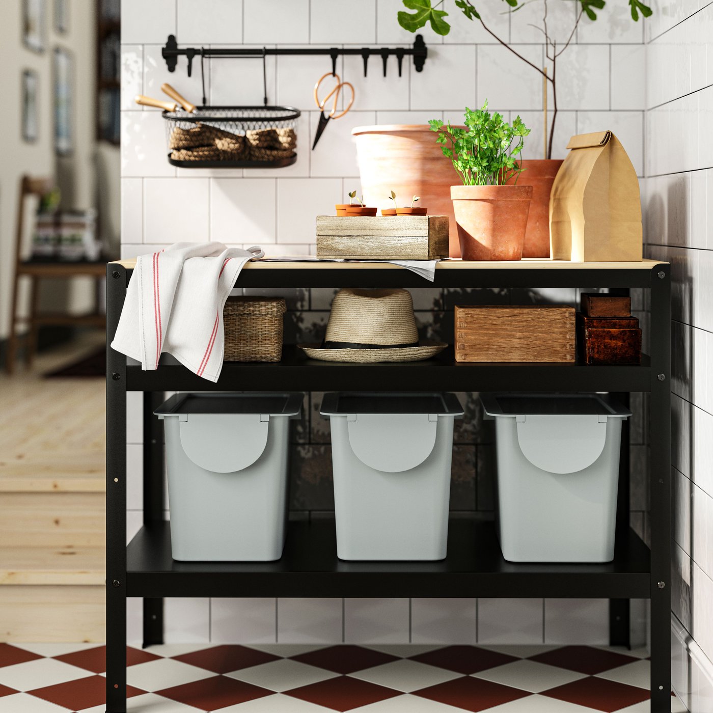 Three light grey-blue TRÖSKNING bins with lid stand on a shelf in a BROR work bench in a kitchen.