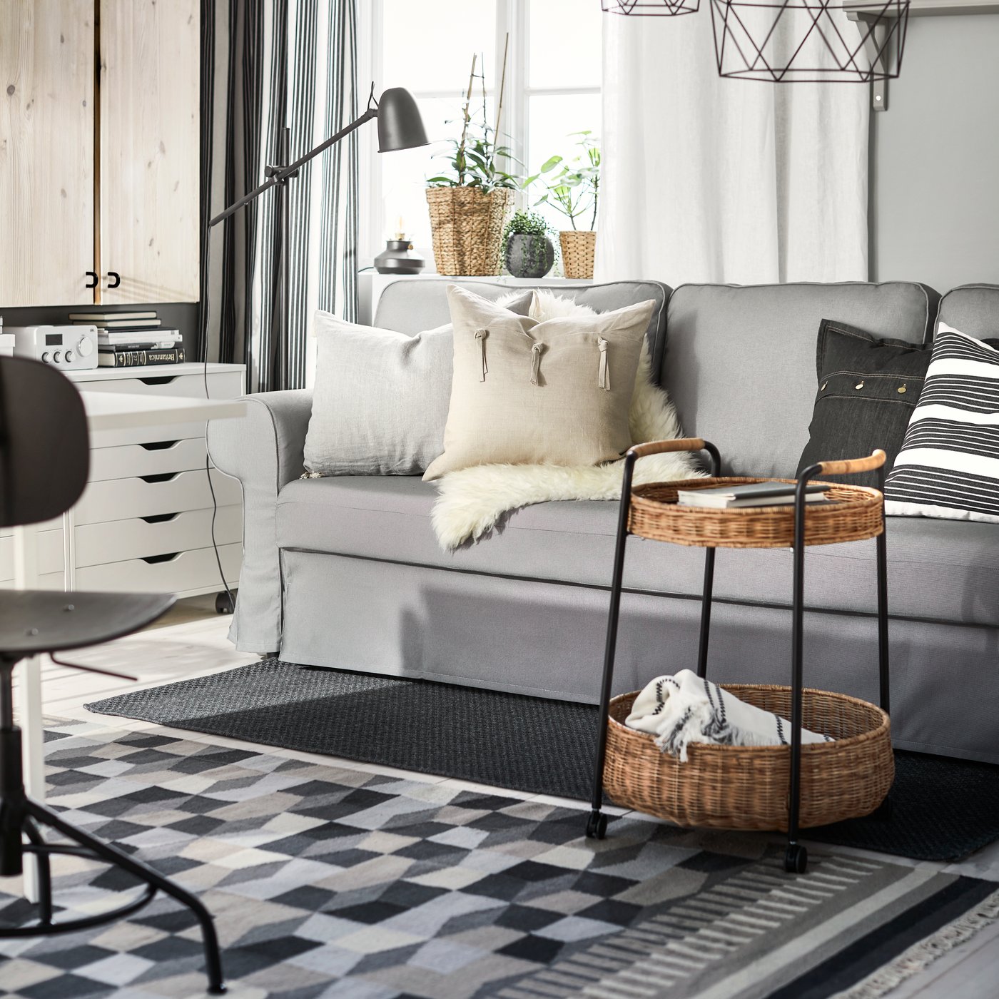 TÅRBÄK alfonbra grisa eta beixa ohe-sofa baten azpiko egongela batean.