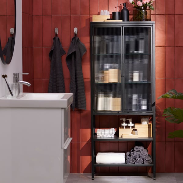 An anthracite MOSSJÖN glass-door cabinet with 2 doors in the bathroom