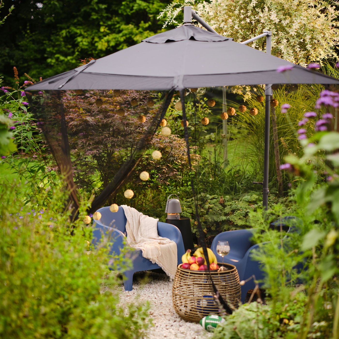 Un espace détente dans un coin de jardin avec des fauteuils d'extérieur SKARPÖ.