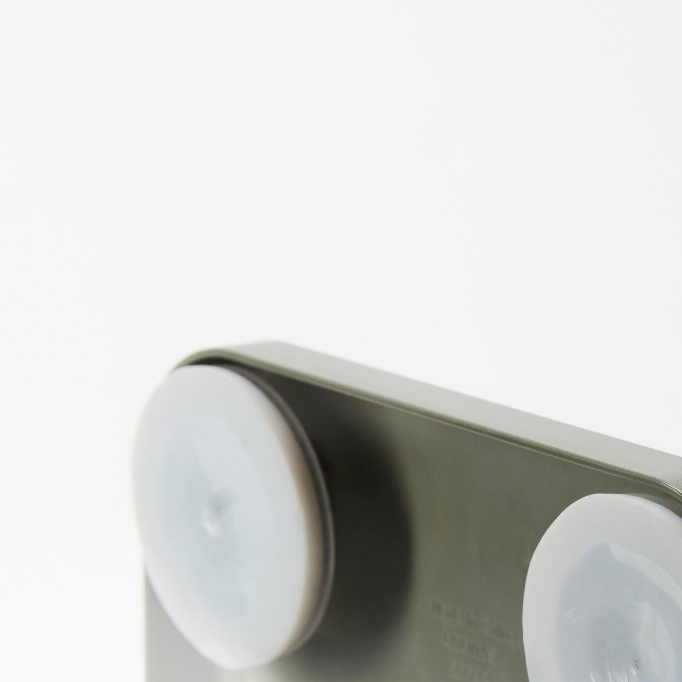 Krupni kadar jednog i djela drugog vakumskog držača na stražnjoj strani ÖBONÄS zidne police. Dio veće slike.