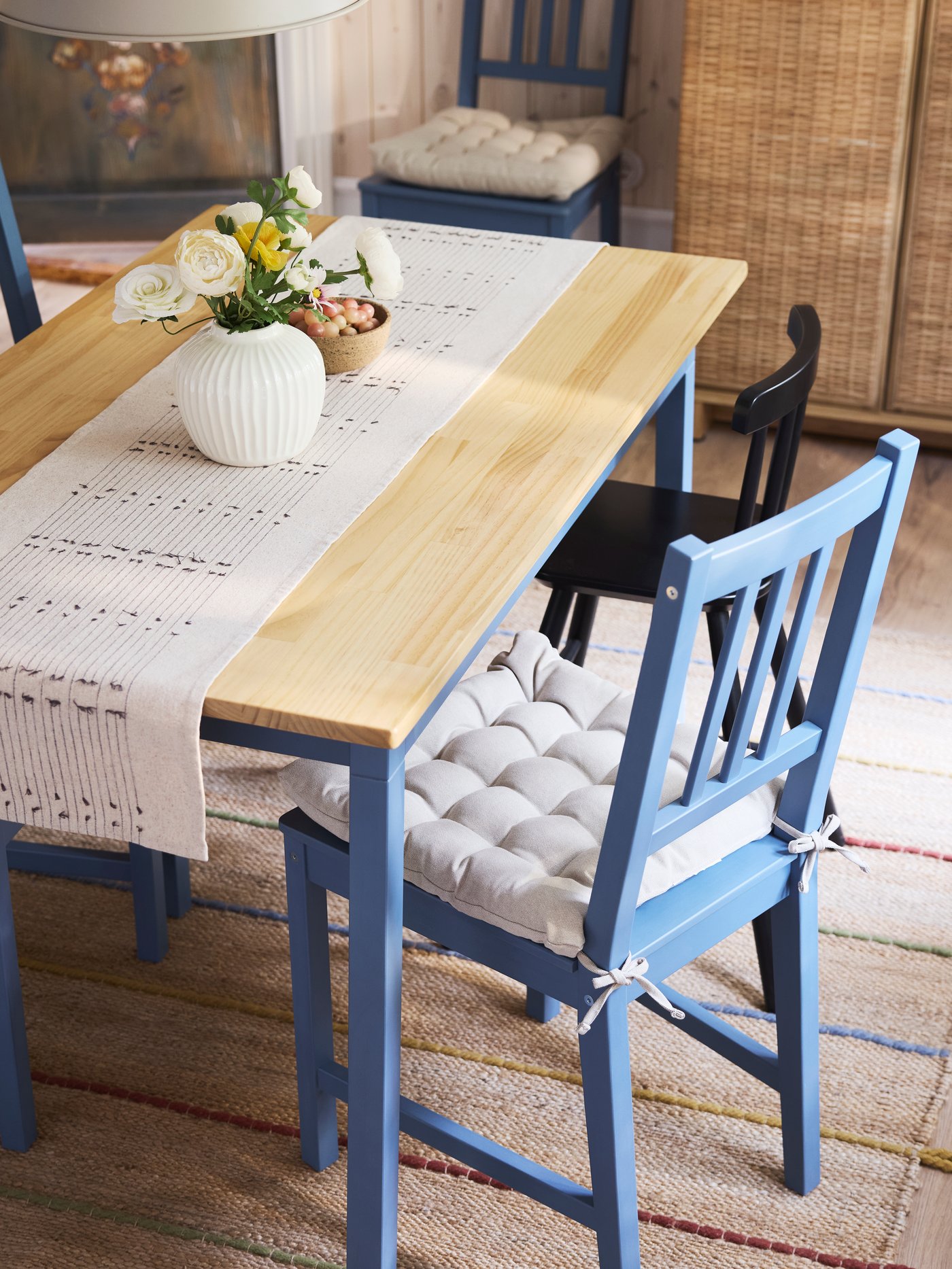 PINNTORP chairs with VIPPÄRT chair pads and an AGAM junior chair stand at a PINNTORP table with a VÅRARV table-runner.