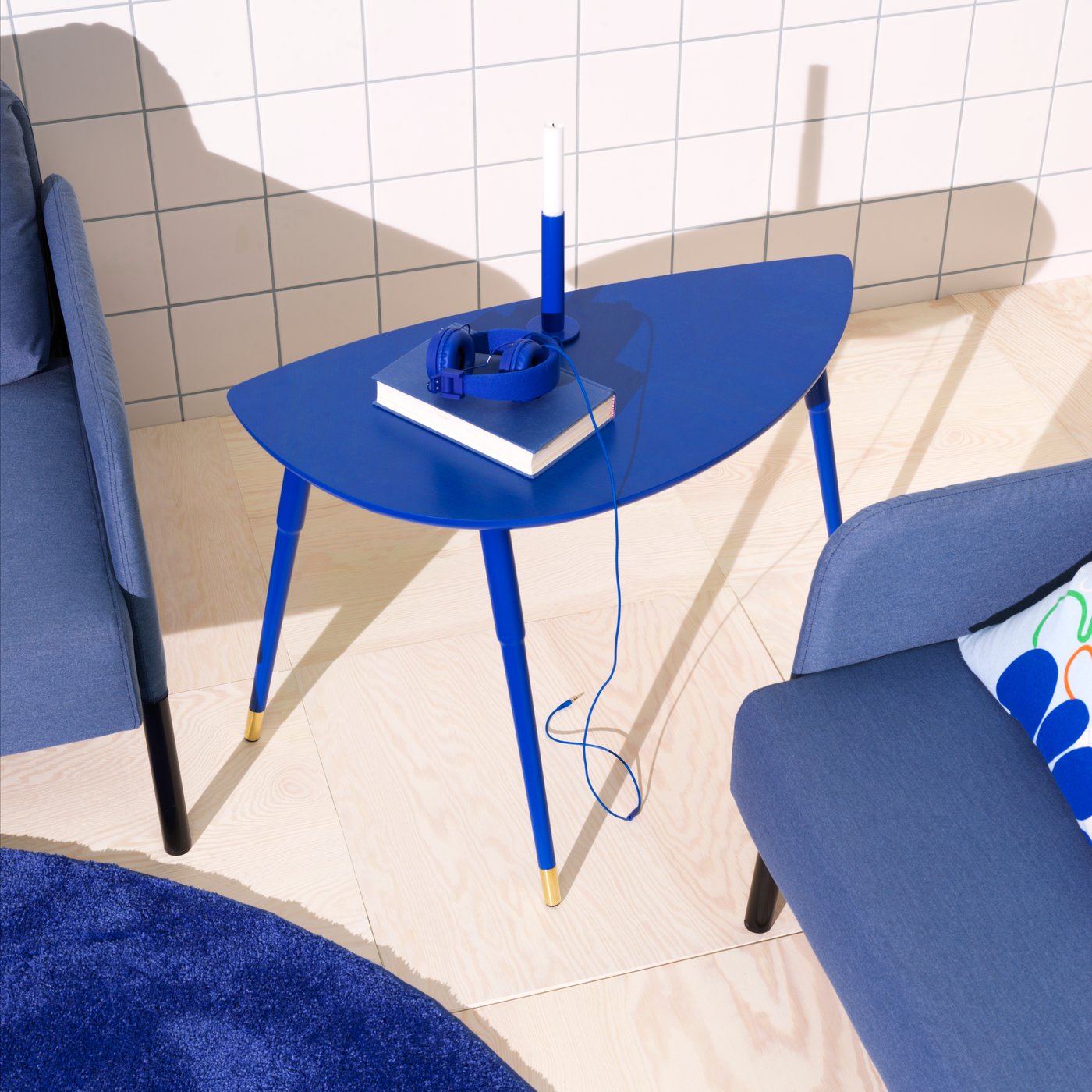 Ett blått LÖVBACKEN soffbord står mellan två blåa fåtöljer.