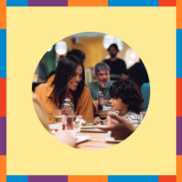 Image ronde montrant une mère et son enfant au restaurant IKEA, sur fond jaune pâle avec bordure de couleurs rouge, bleu, violet, orange et vert.
