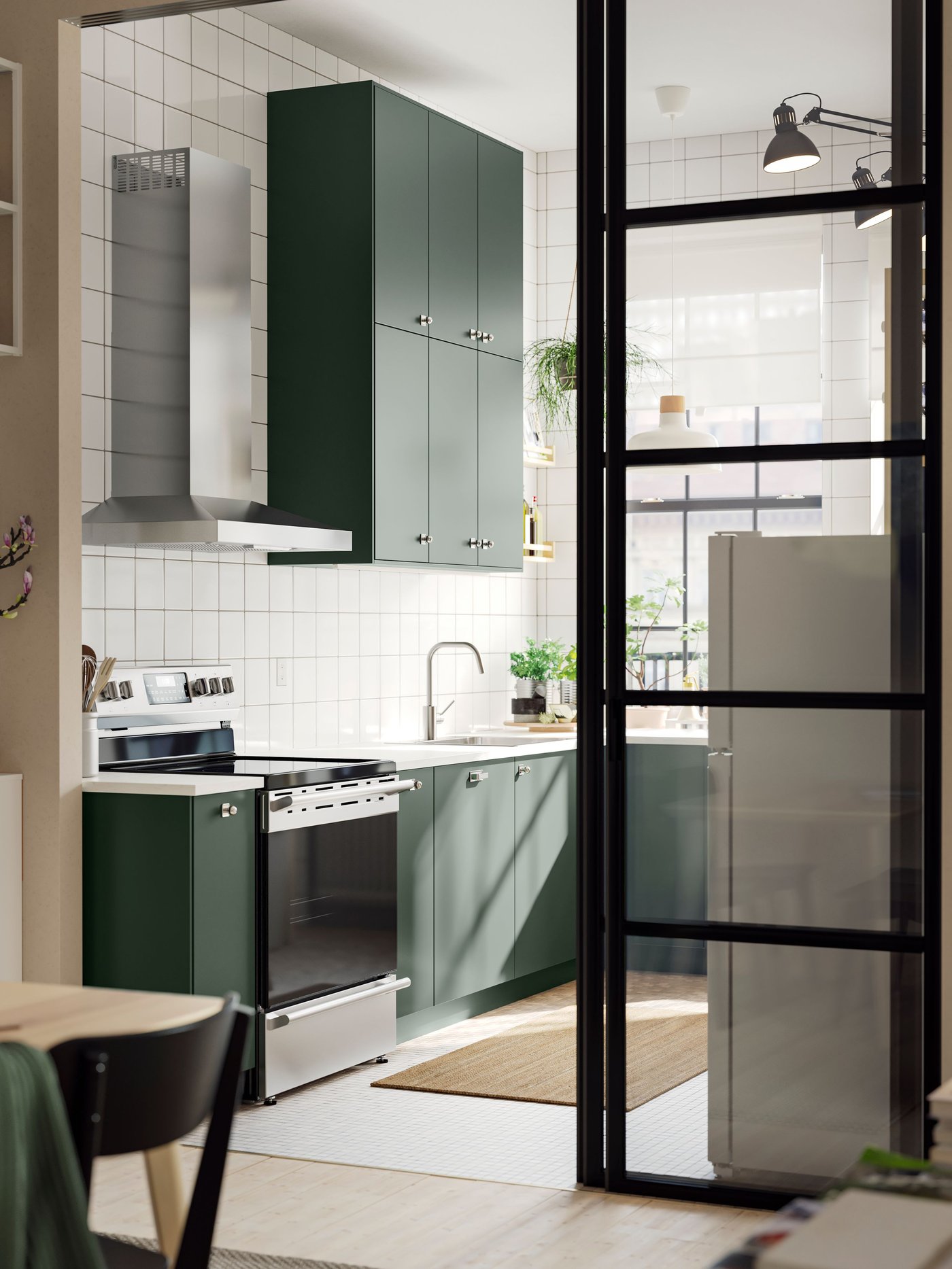 A wide doorway into a kitchen with deep green HAVSTORP kitchen fronts and a white marble effect/laminate EKBACKEN worktop.