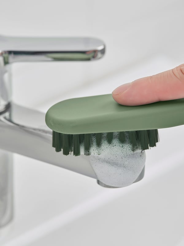 A green PEPPRIG scrubbing brush
