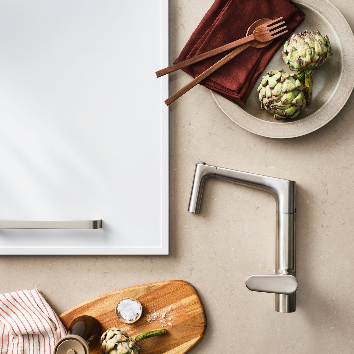 A close-up of the stainless steel MAJSJÖN kitchen mixer tap pull-out with spray, set against a modern kitchen combination.