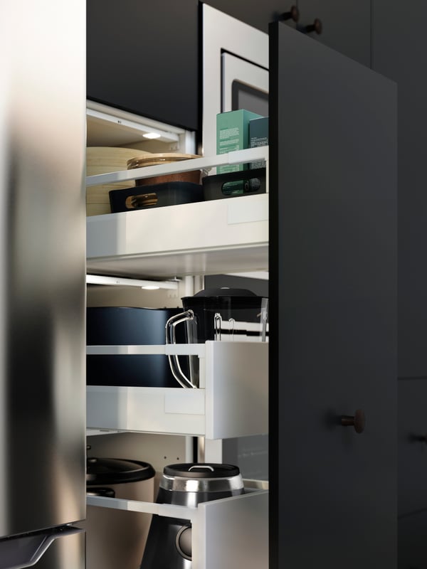 A kitchen cabinet showing MAXIMERA drawers filled with various kitchen utensils, appliances and containers.