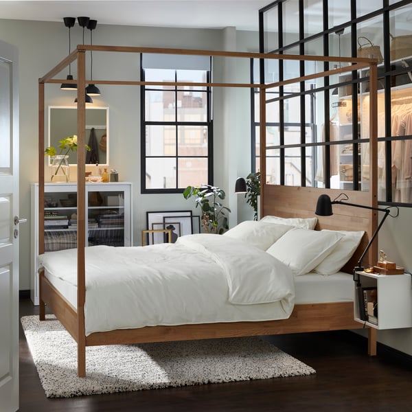 Ein YTTERVÅG Himmelbett steht in einem großzügigen Schlafzimmer