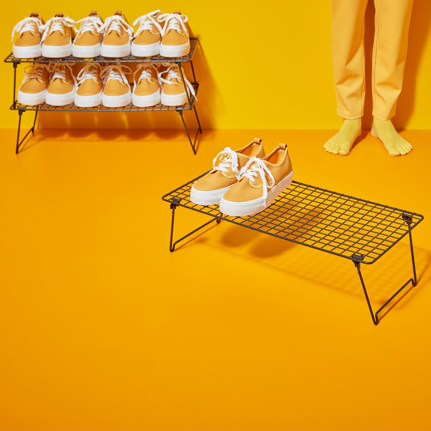 En GREJIG skohylla med gula skor på i ett gult rum.