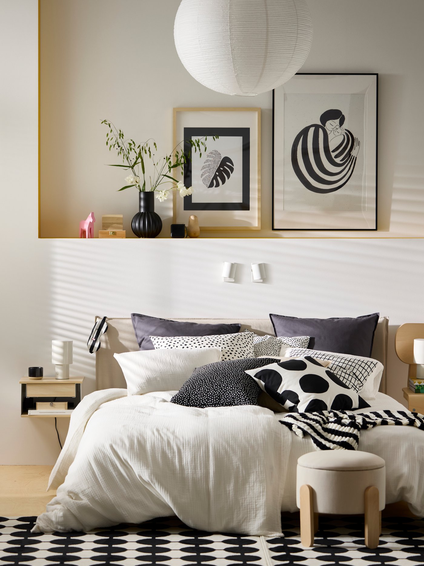 A large bed made up with lots of pillows and cushions as well as a white muslin SCHERSMIN duvet cover and pillowcase set.