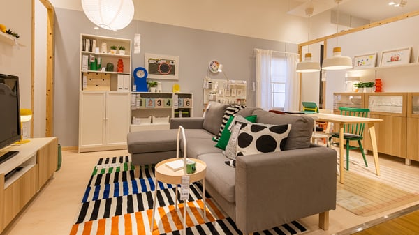 カラフルなカーペット、クッションと、ホワイトのシンプルな家具が配置されている。