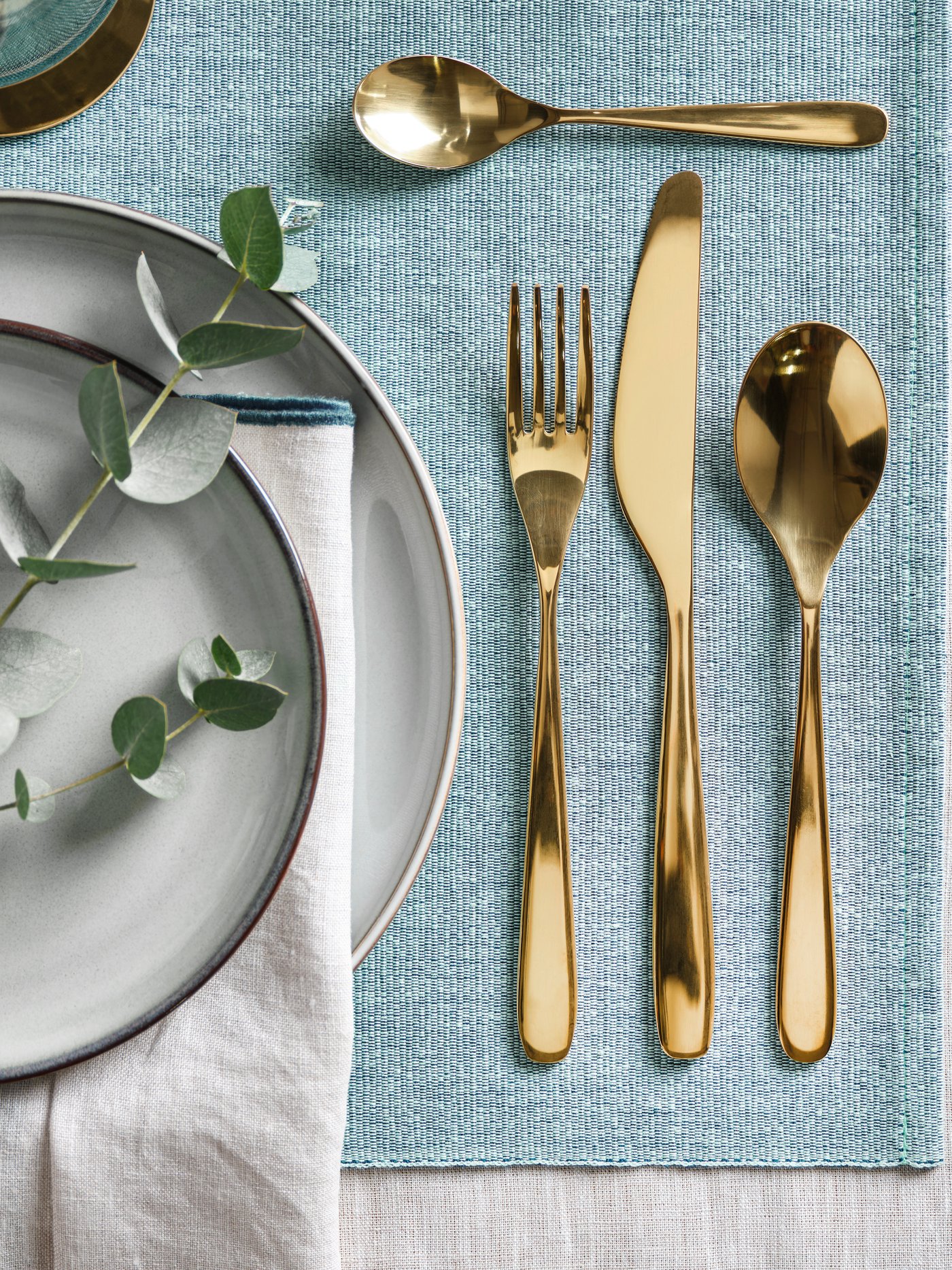 Ein messingfarbenes 24-teiliges Besteckset von TILLAGD