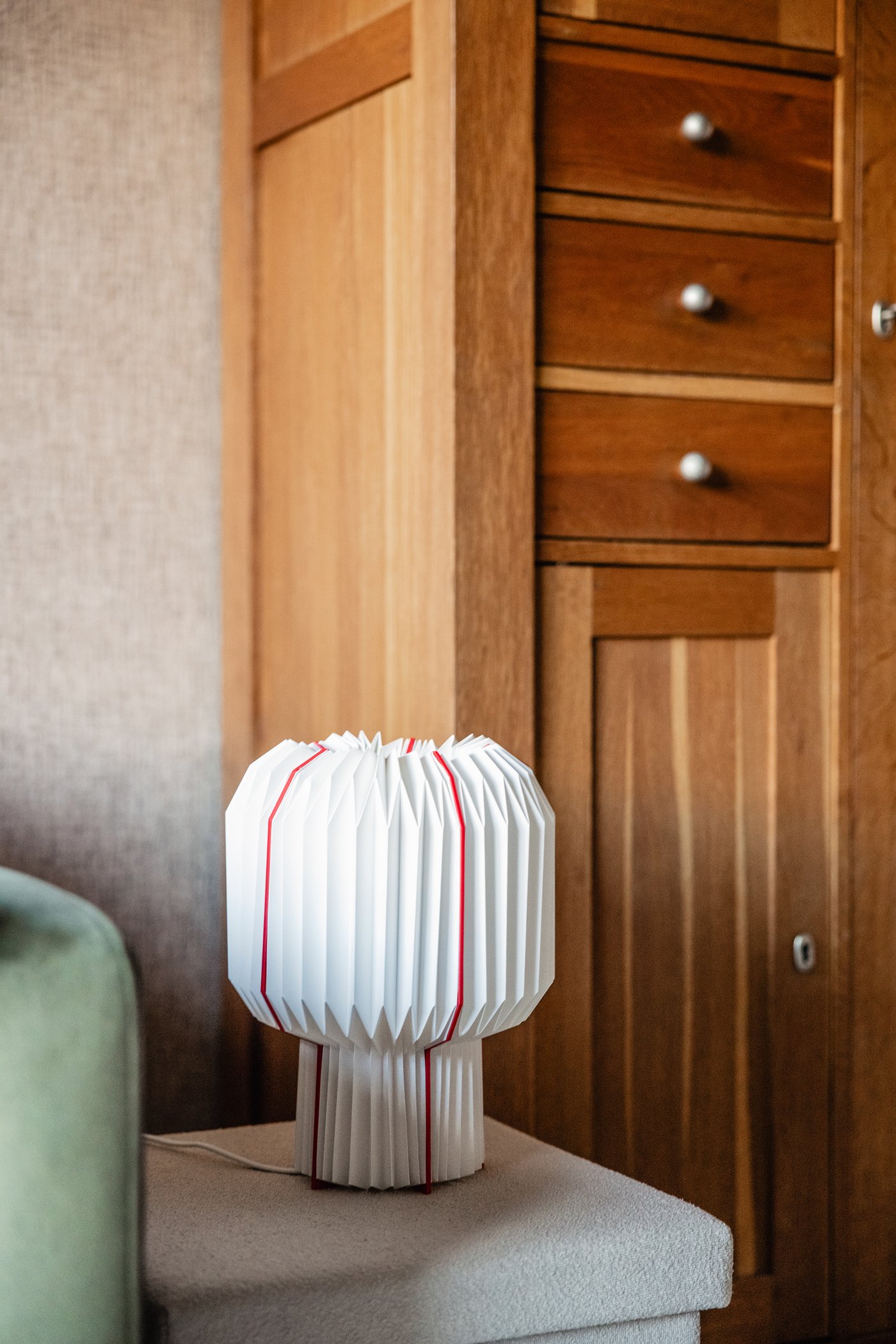 Een bijzettafel met daarop een wit/rode STRÅLA lamp.