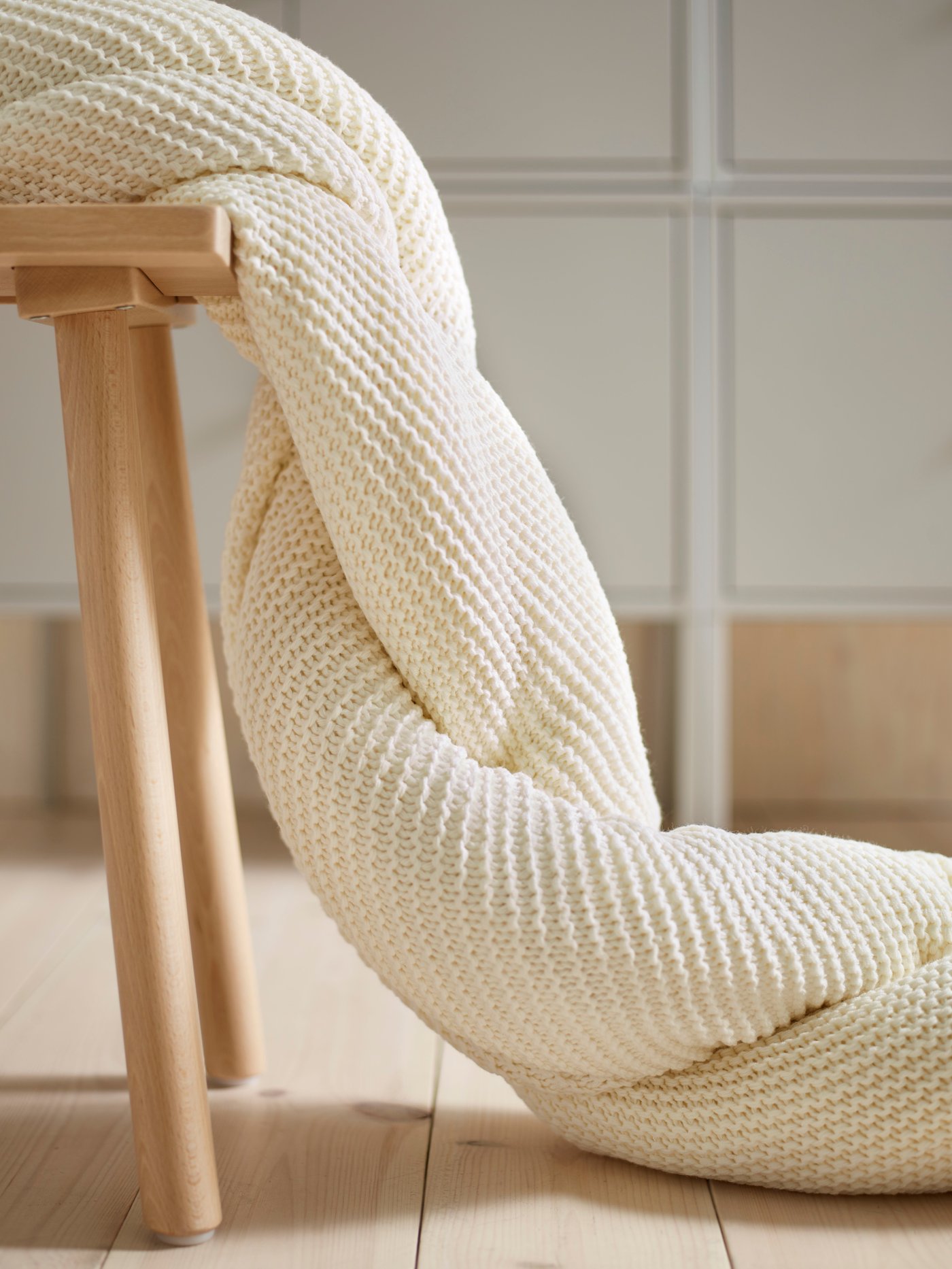 An INGRITA throw hanging off a wooden chair.