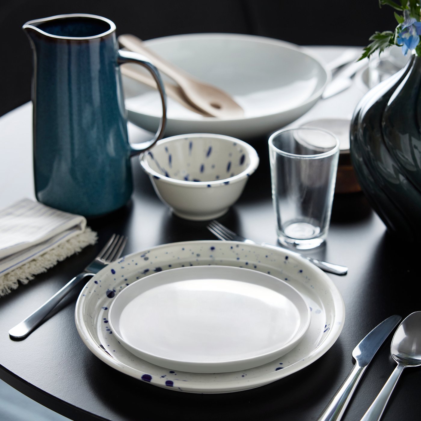 Une assiette à dessert IKEA 365+ est posée sur une assiette SILVERSIDA, à côté d'un saladier SILVERSIDA et d'un pichet bleu GLADELIG, sur une table.