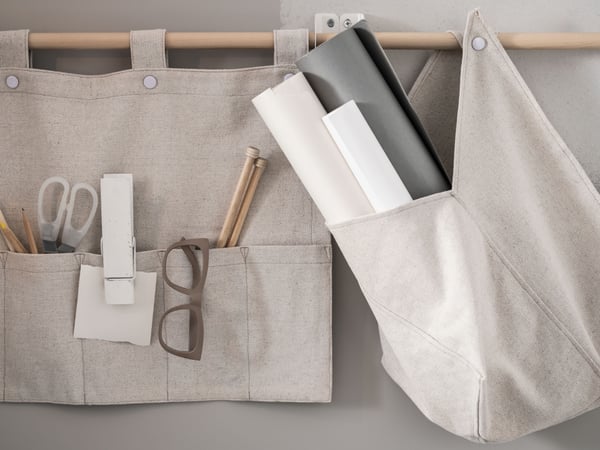 Hanging storage with papers, glasses, pens and scissors.