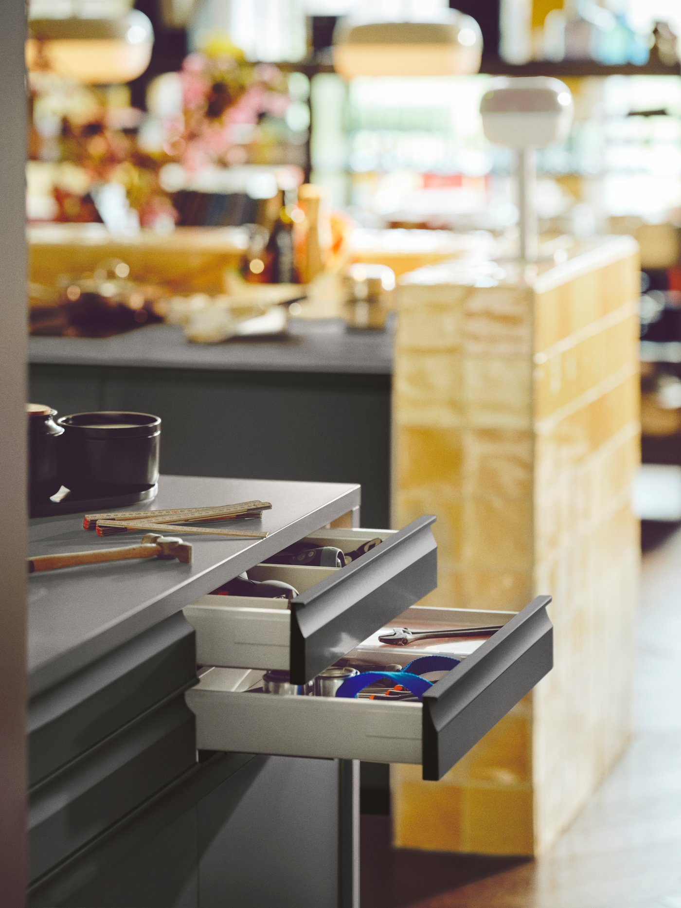 UPPLÖV kitchen drawer fronts are on open drawers, showing tools inside. A countertop and dining area are beyond.