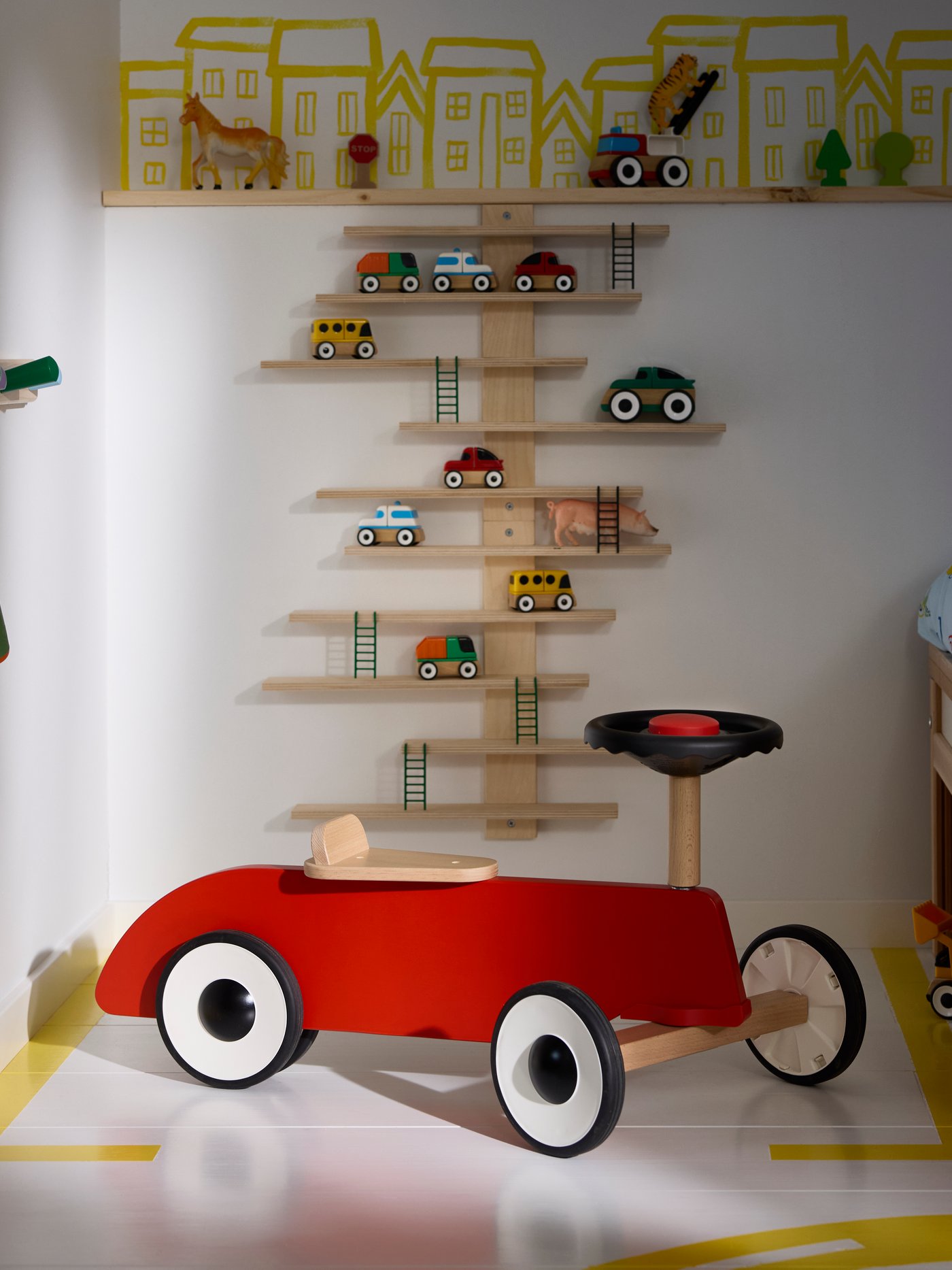 Ein FÄLTHARE Rutschauto ist in einem Kinderzimmer zu sehen