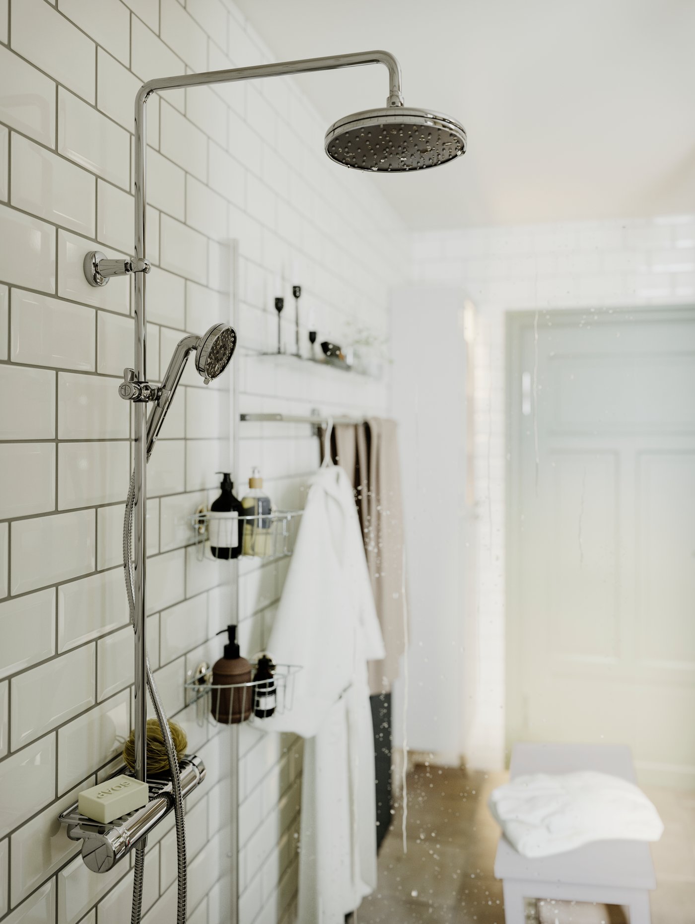 Vista del  interior de una ducha con un set de ducha VOXNAN con dos tipos de cabezales. También se ven organizadores de ducha que sostienen shampoos y jabones.