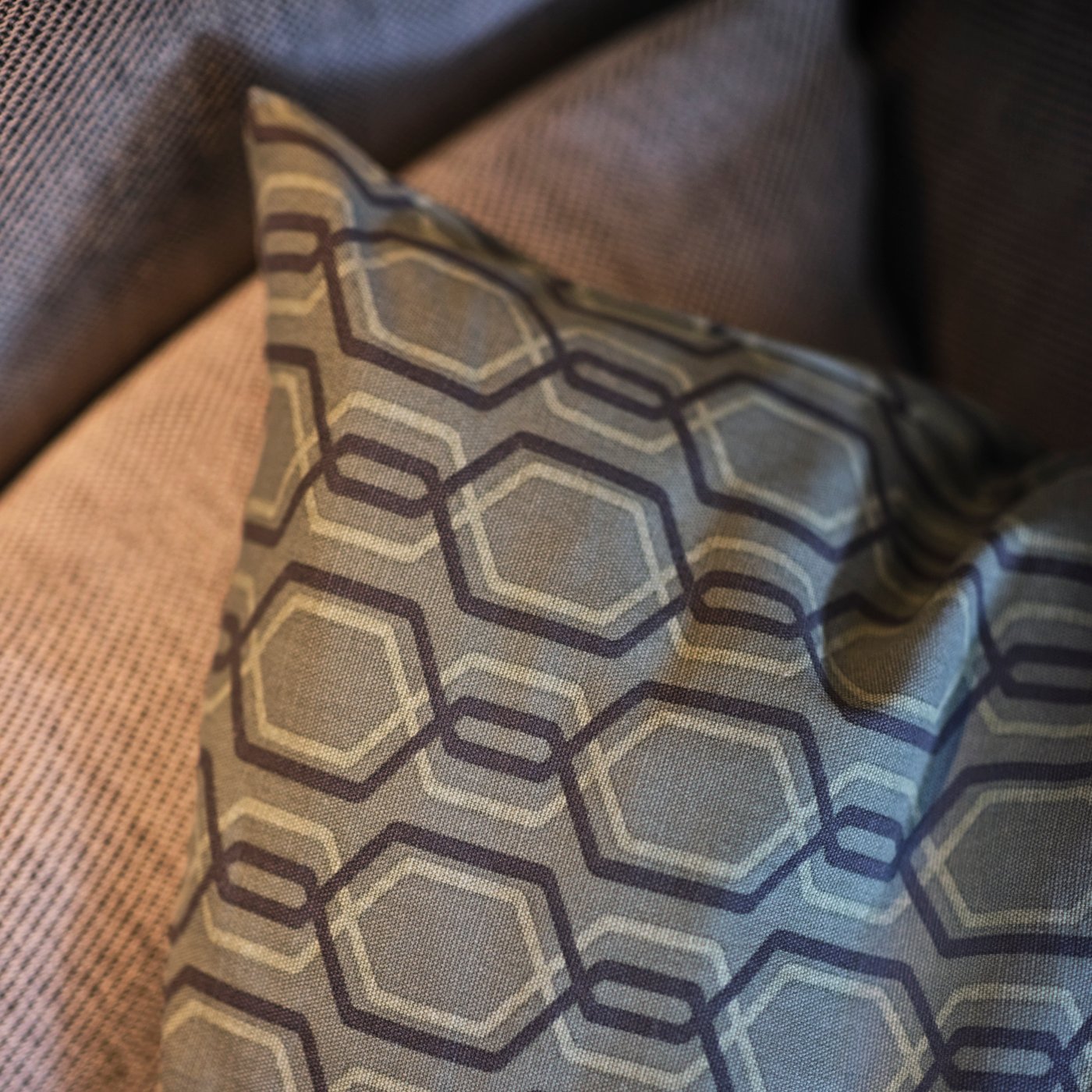 A close up of a cushion in a grey/green JÄTTEPOPPEL cushion cover on a sofa.