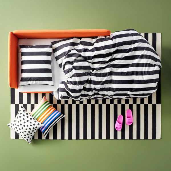A black/white/striped SLÅNHÖSTMAL duvet cover and pillowcase