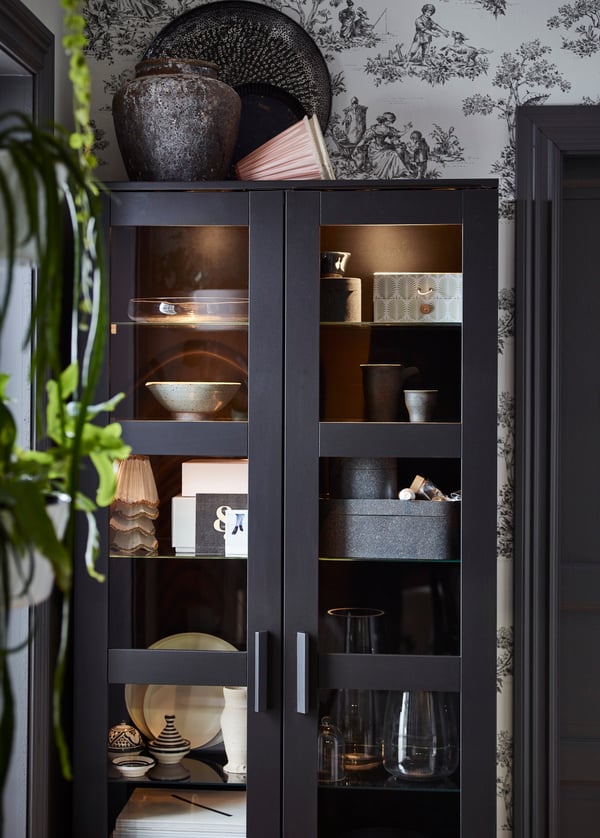 An IKEA BRIMNES storage unit in dark blue is filled with all-sorts of collectables.