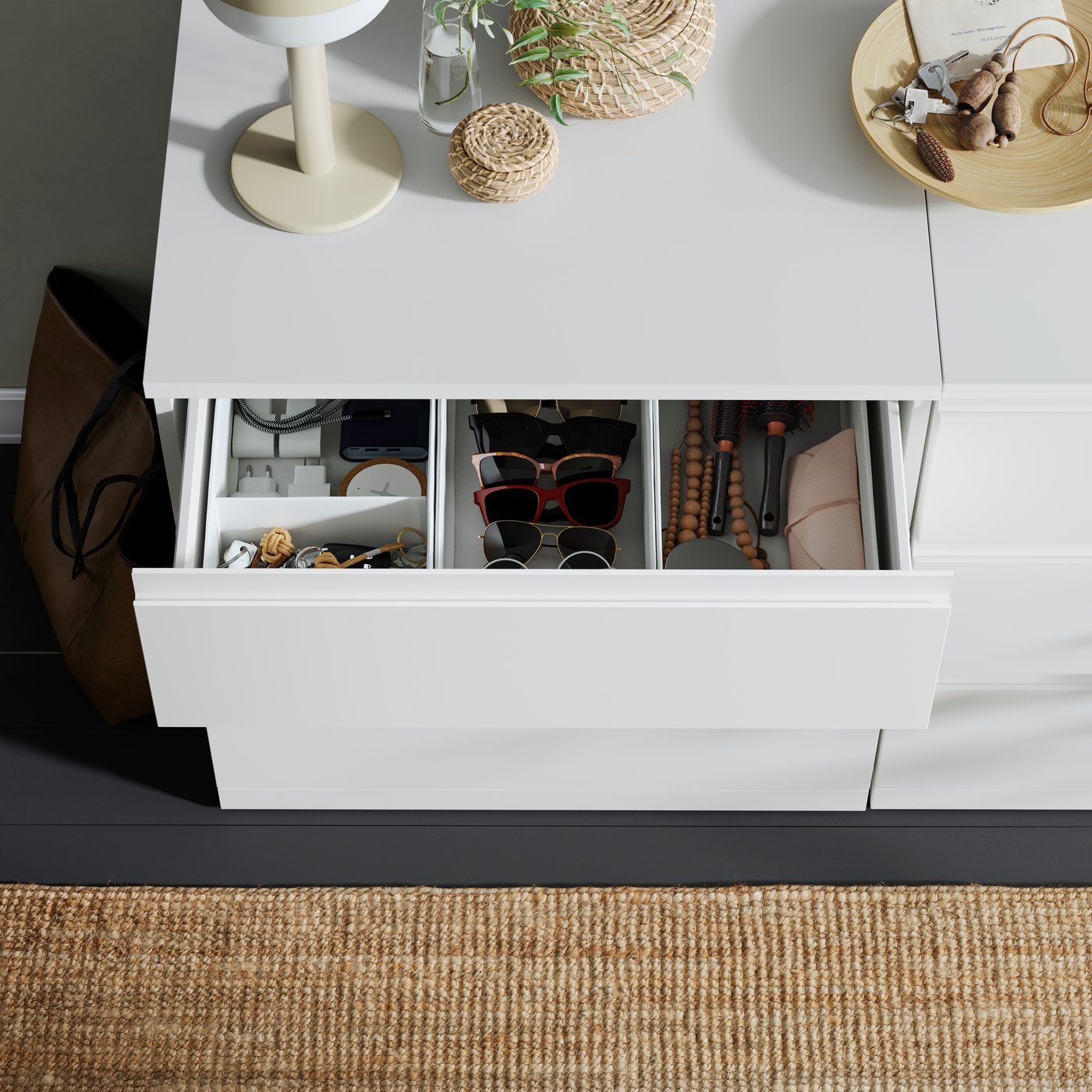 A bird’s-eye view of an open drawer of a STORKLINTA chest of 3 drawers. Inside is organized with boxes and dividers.