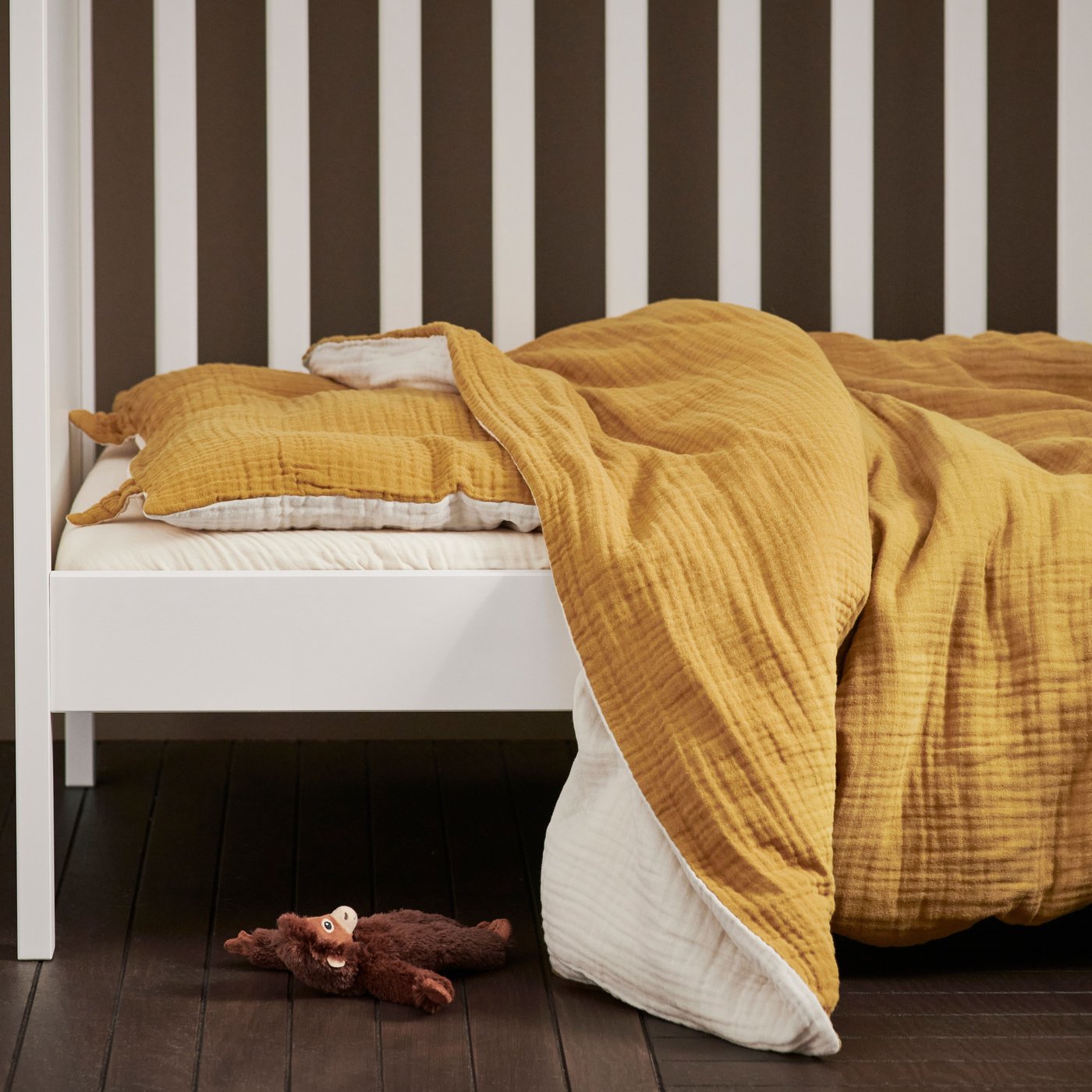 A dark yellow/beige GULDVÄVARE 3-piece bedlinen set for cot in the childrens room
