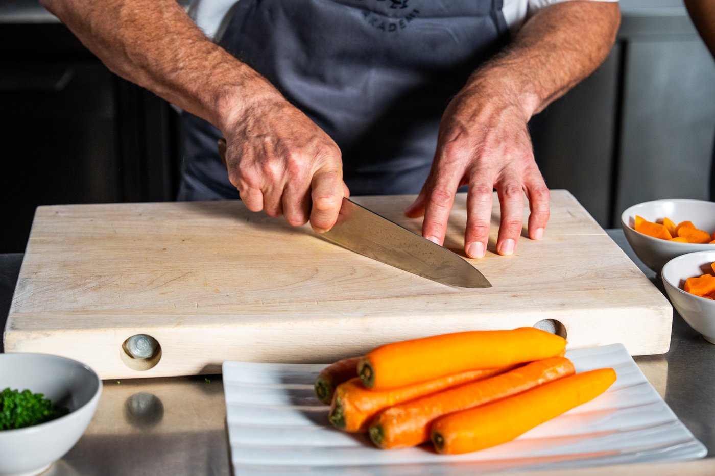 En kokk skjærer med kokkekniv.