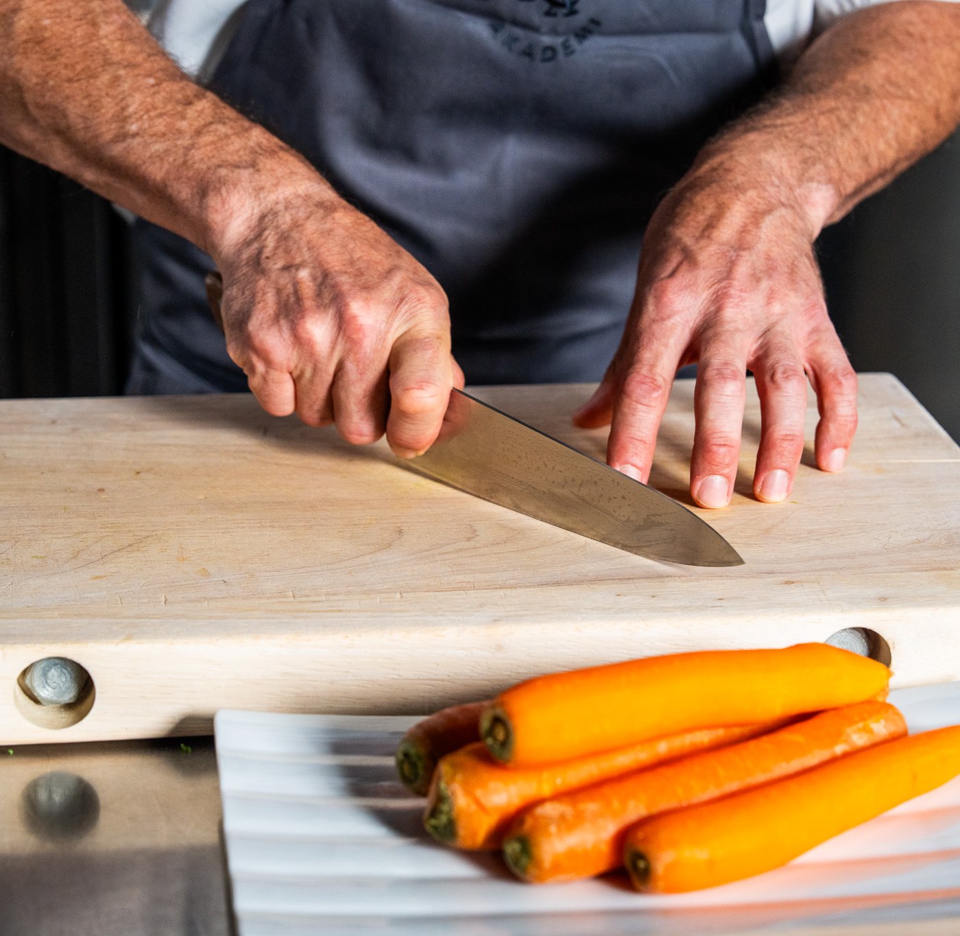 En kokk skjærer med kokkekniv.