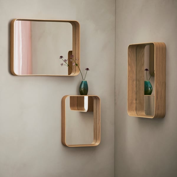 Three wall-mounted DVÄRGSYREN mirrors in different sizes and shapes. There’s a reflection of a pink curtain in one of them.