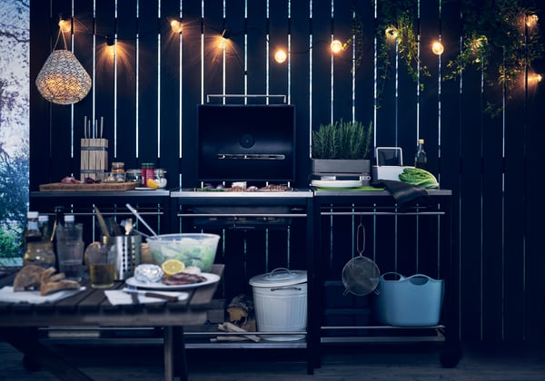 A black KLASEN charcoal barbecue insert outside.