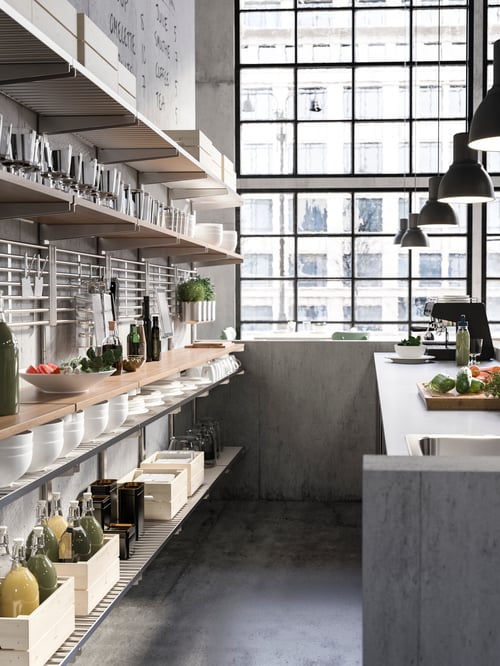 Kitchen featuring a suspension rail with shelves and wall grid, containing boxes. Pendant lamps hang above a tabletop.
