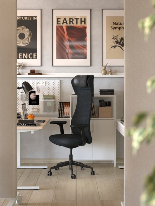 A workspace that includes a GRÖNFJÄLL office chair with armrests and a headrest, a cabinet, and an acoustic screen.