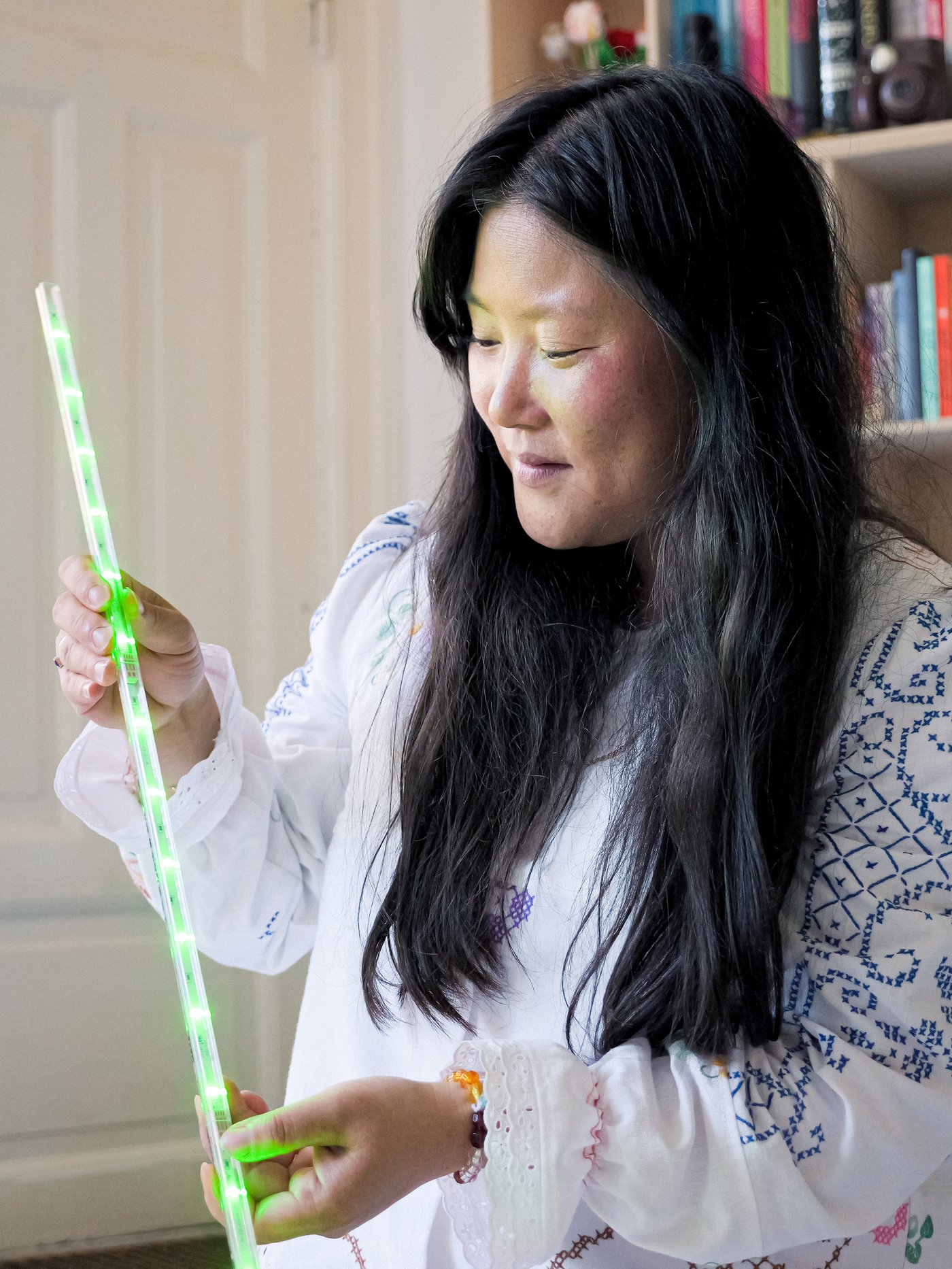 Una donna tiene in mano una barra luminosa LEDBERG verde.