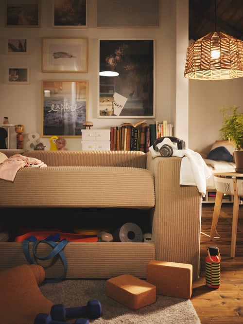 Wohnzimmer mit einem JÄTTEBO 3er-Sitzelement neben einem STARKVIND Tisch mit Luftreiniger und einem KAPPELAND Hängeleuchtenschirm darüber.