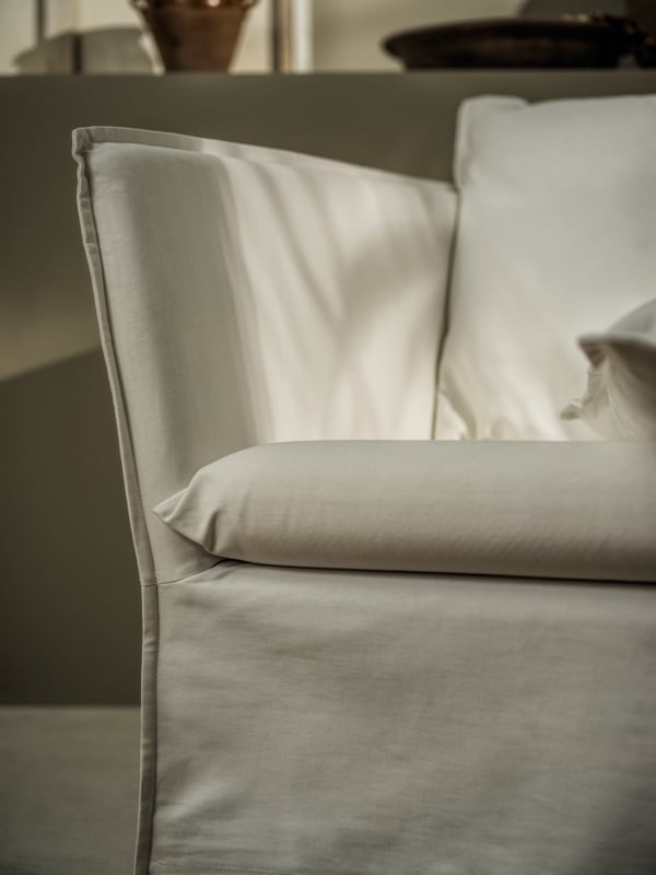 A BACKSÄLEN 1.5-seat armchair in Blekinge white with sunlight and shadows on its surface.