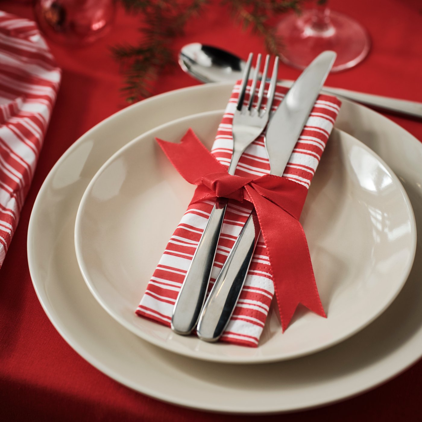 Servilleta con diseño navideño VINTERFINT sobre platos blancos.