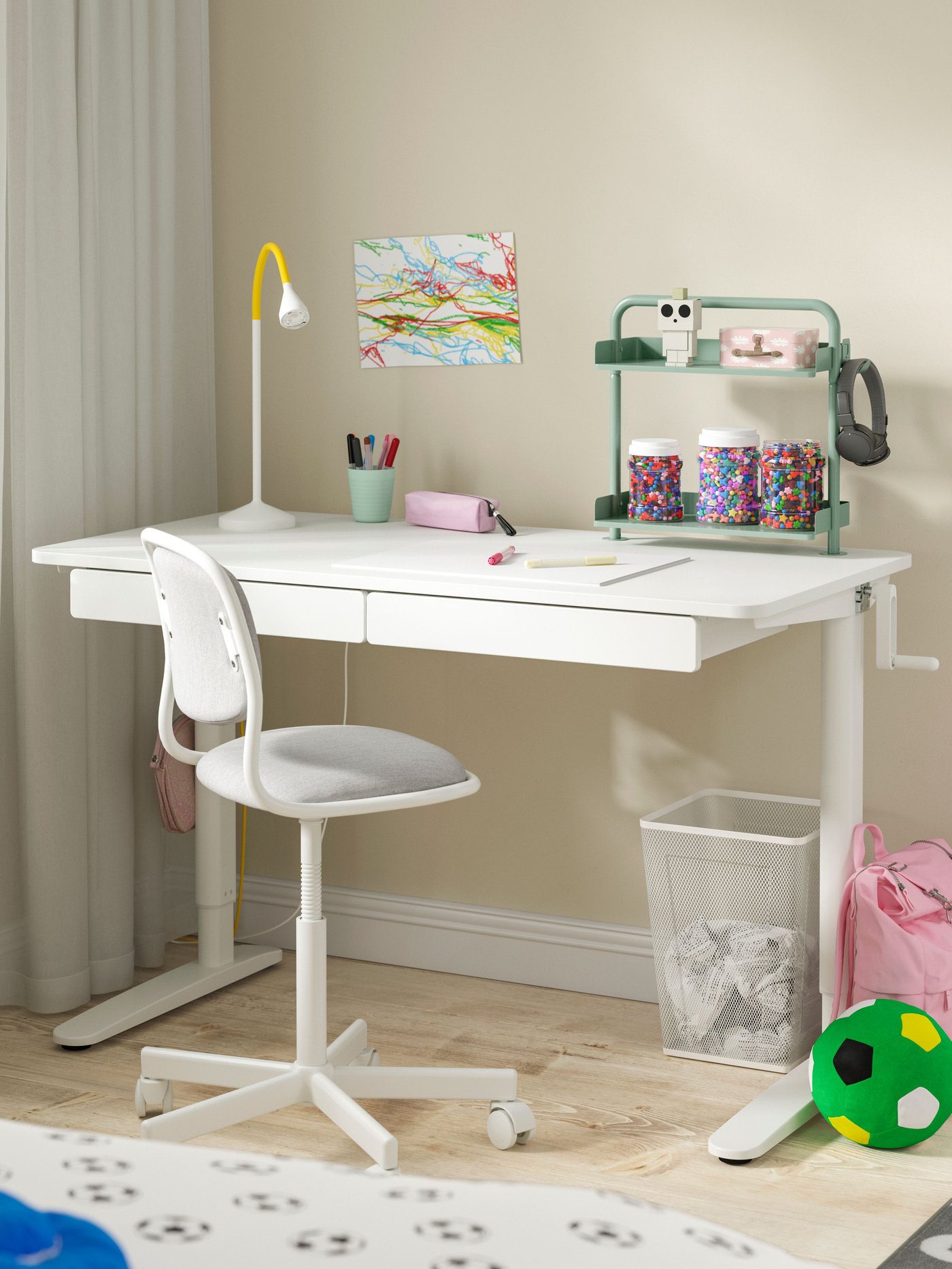 Una scrivania RELATERA per bambino con altezza regolabile e con una sedia senza braccioli e con rotelle.