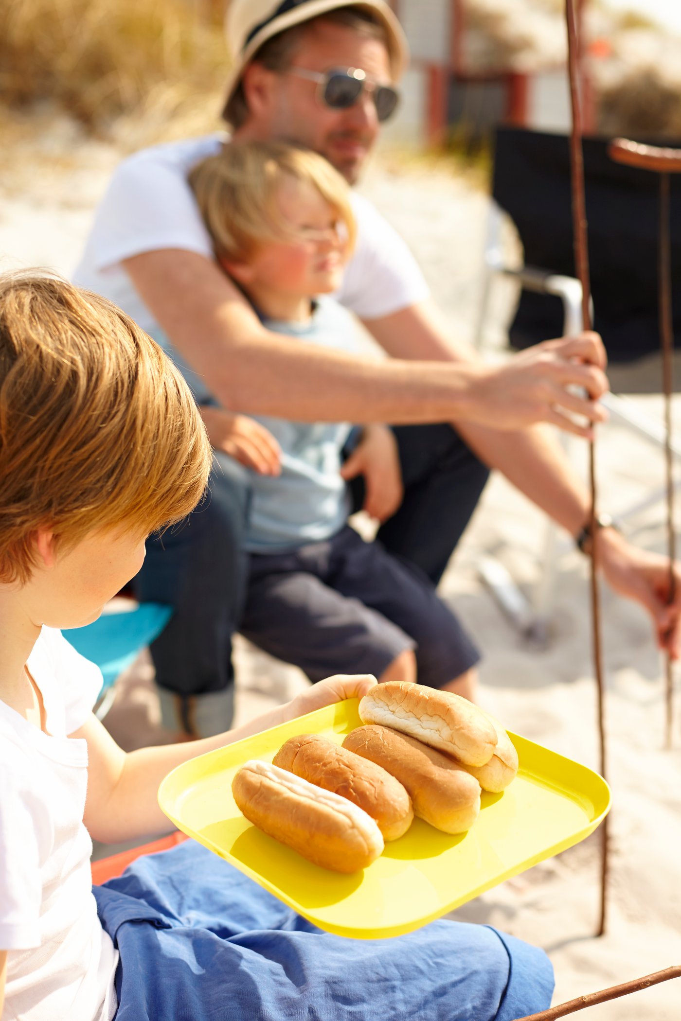 Kid holds yellow plate with hotdogbuns