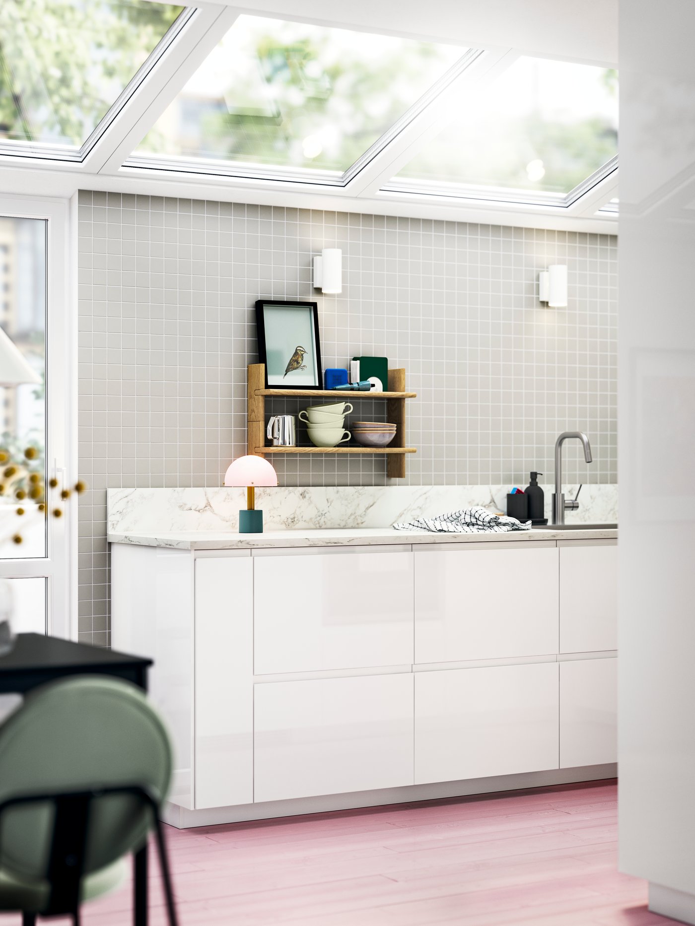 Una cocina llena de luz con VOXTORP en blanco brillante y estantes abiertos con cuencos y decoración colorida.