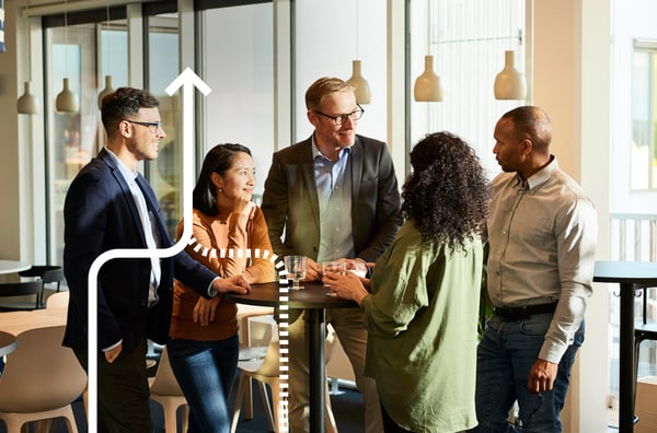 Arbeitskollegen sprechen miteinander an einem Konferenztisch im Stehen