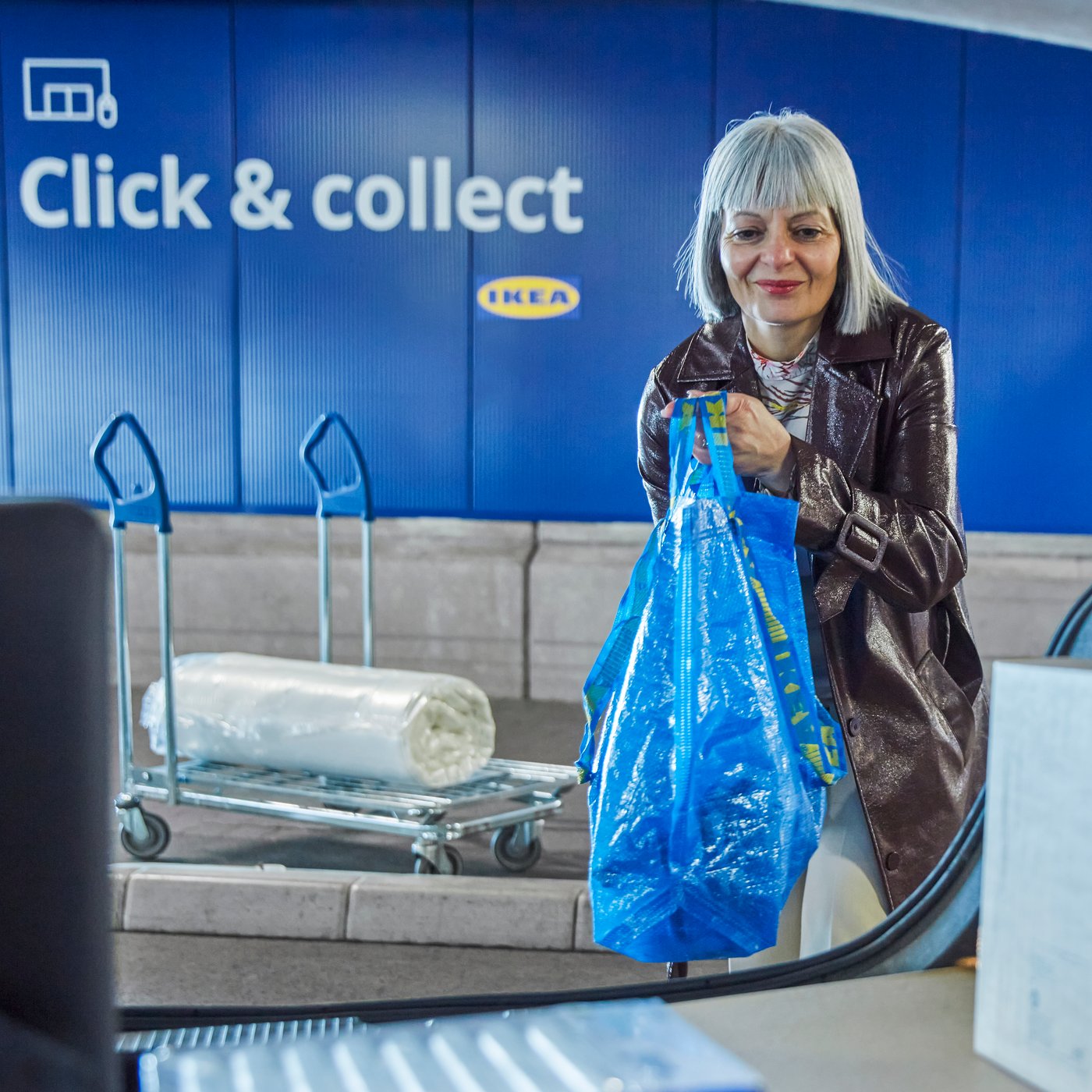 Женщина кладёт сумку в машину.
